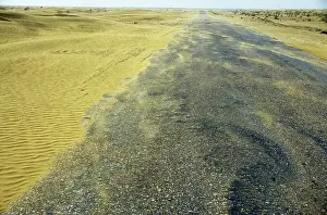 Karakum: Sand dunes in a wind - Karakum desert encroach on a road