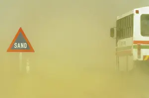Driving: Sand Road Sign and sandstorm at the B 2 tarred road