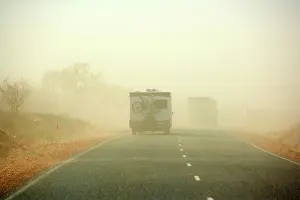 Caravan: Sandstorm - a hugh sandstorm sweeps over a road