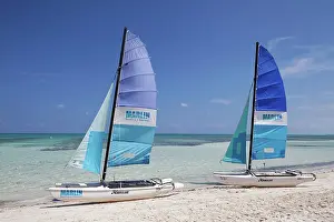 Mooring: Sandy beach beach with two catamarans, blue sails