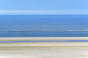 Incoming: Sandy beach beach with incoming waves and blue sky