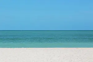 Silence: Sandy beach with blue sky and horizon of calm se