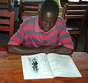 Books: Schoolboy reading books, Uganda