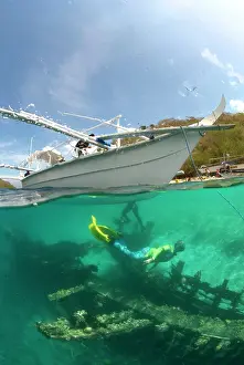 Auscape International: Scuba Diver - beneath dive boat to explore a timber