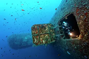 Wrecks: Scuba diver emerging from the hatch at the bow