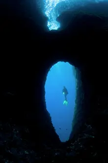 Amalfi: scuba diver in a swimm through, Marine Protected area Punta