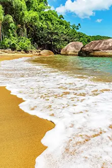 Resort: Sea foam advancing over the sand on the beach surrounded