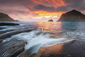 Spray: Sea surf in warm evening light with coastal landscape