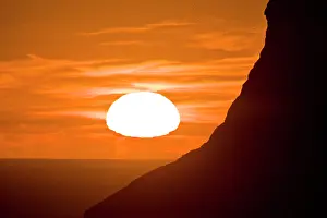 Midnight: Seabirds fly off the cliffs as the midnight