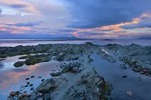 Magellan: Seascape at dusk - pink clouds at dusk over rocky
