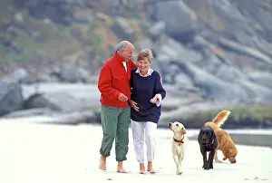 Senior: Senior Couple - taking a walk on the beach with dogs