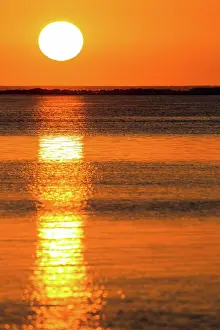 Mauritius: The setting sun is reflected in the calm waters o