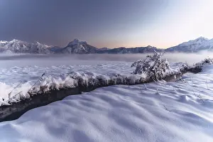 Sun Sets: Shortly after sunset, twilight at Lake Hopfensee in the Allgau in Bavaria in a winter landscape