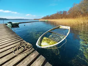 Rowing: Sinking boat at Schaalsee, wooden jetty in the reeds
