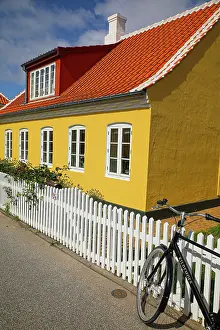 Bicycle: Skagen, Denmark. Bike, yellow house with white picket fence