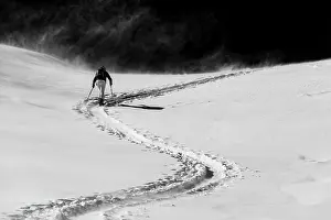 Monochrome: Ski mountaineer in winter landscape against a dark