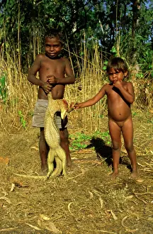 Goanna: Two small boys.with beheaded goanna. Arnhemland