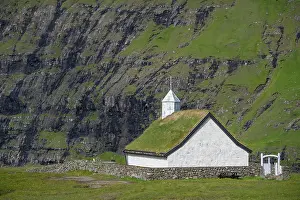 Faroe: Small church with grass roof in mountain landscape