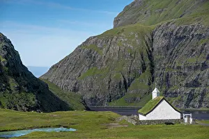 Faroe: Small church with grass roof in mountain landscape