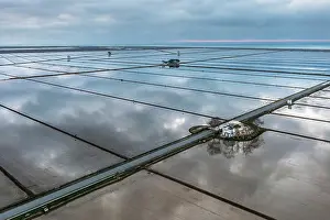 Flooded: Small farm cottage amidst flooded rice fields in
