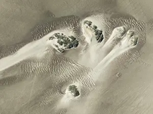 Desertification: Small sand heaps form around the sparse vegetation in the Namib Desert