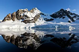 Lemaire: Snowy Artic mountains mirror in the sea