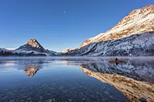 Paddling: Solo canoe goes by as Sinopah Mountain reflects