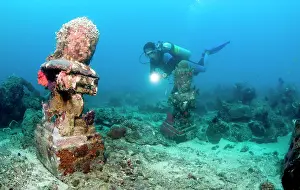 Pemuteran: Statue with coral growth on it