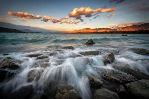 Swell: Stones on shore, lake with sunset swell, long time