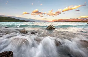 Swell: Stones on shore, lake with sunset swell, long time