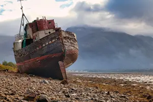 Loch: Stranded fishing boat and Ben Nevis from the shore