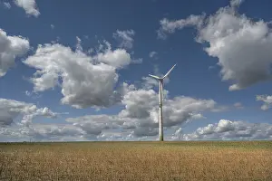 Energy: Stubble field, wind turbine and cloudy sky