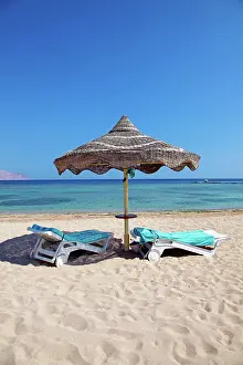 Umbrellas: Summer holiday beach umbrella by the sea and sun lounger