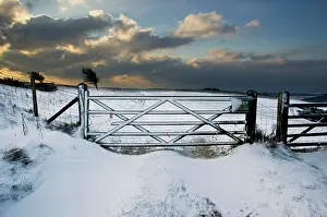 Bursting: Sun bursting through clouds over a snowy landscape