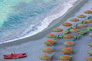Lifeboat: Sun loungers, parasols and red lifeboat on the beach