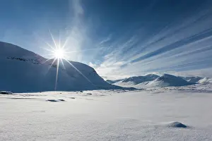 Swedish: Sun over mountain range in the snow, Kungsleden