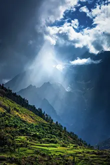 Rays: Sun rays through clouds in Himalayan valley in Himalayas