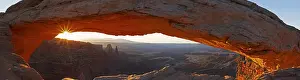 Rises: The sun rises through Mesa Arch in Canyonlands