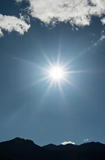 Orthographic: Sun shines brightly in a star shape in the bright