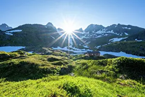 Reflex: Sun shining on mountains with snow, mountain range