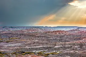 Sunrays: Sunrays over striated, dramatic, badland hills