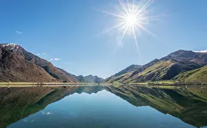 Howse: Sunstar, mountains reflecting in lake, Moke Lake
