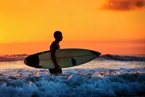 Half: Surfer at sunset, Sanur Beach, Bali, Indonesia
