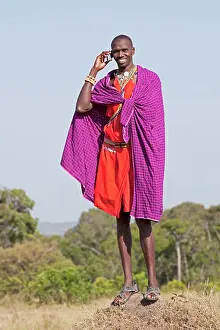 Phone: Tall Maasai man wildlife guide using mobile phone