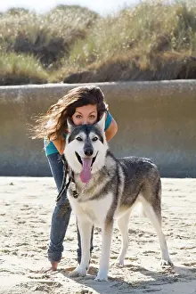 Malamute: Teenage Girl with Alaskan Malumute (cross) dog on beach