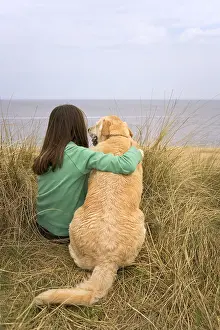 Loyalty: Teenage girl with labrador dog on sand dunes - Norfolk UK