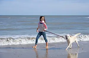Teenage: Teenage Girl Walking Labrador Dog on Beach