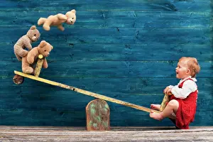 Child: Three-year-old girl with teddy bear on seesaw, A