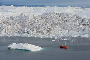 Midnight: tourist boat in front of large icebergs