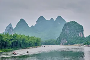 Yangshuo: Tourist boats on Li river with dramatic karst mo